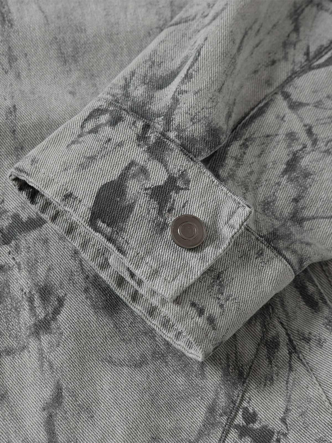A focused view on the sleeve detail of TALISHKO tie-dye denim bomber jacket, highlighting its unique texture.