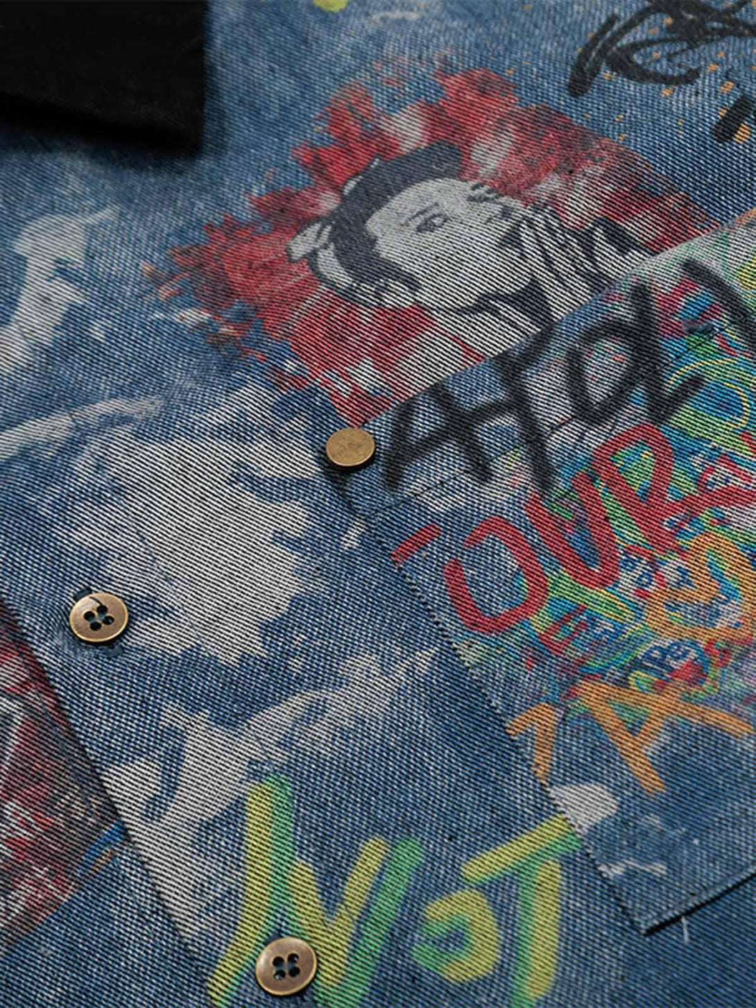 A tight crop highlighting the artistic graffiti design on TALISHKO's tie-dye denim polo.