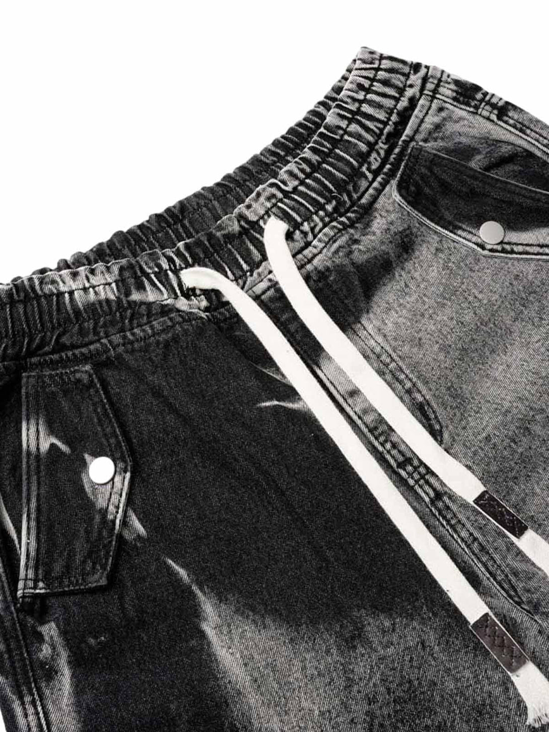 A close-up of TALISHKO tie-dye cargo jorts, highlighting the drawstring and pocket details.