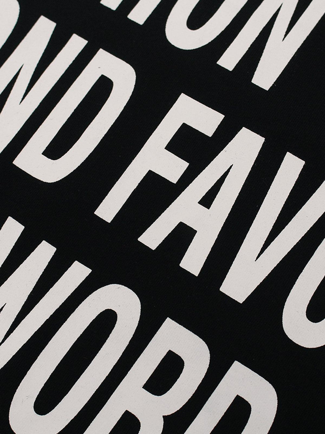 Zoomed-in view of TALISHKO's statement T-shirt, featuring bold white typography on black fabric.