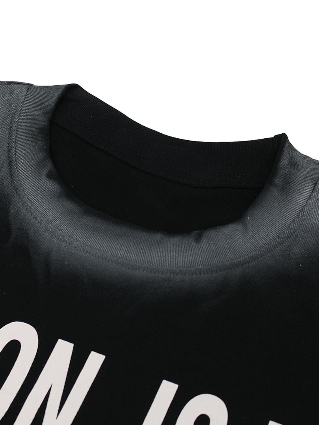A detailed view of TALISHKO's tie-dye statement T-shirt collar, showcasing bold white text.