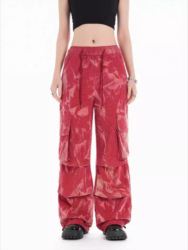 Model wearing red tie-dye corduroy pants with multiple pockets by TALISHKO.