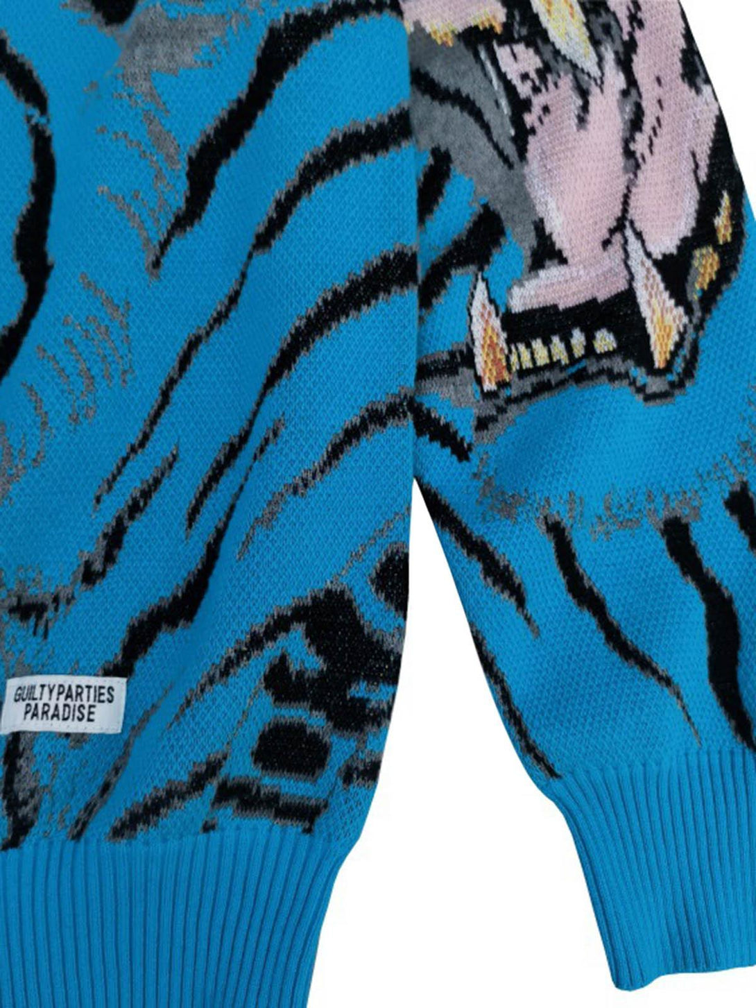 Detailed fabric and stitching on TALISHKO's blue tiger-patterned sweater, highlighting dynamic design.