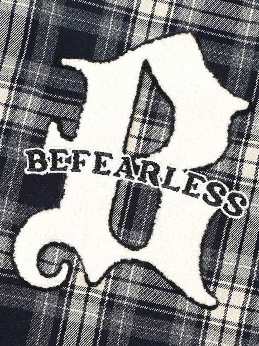 A detailed view of towel embroidery on a plaid shirt by TALISHKO, highlighting unique design.
