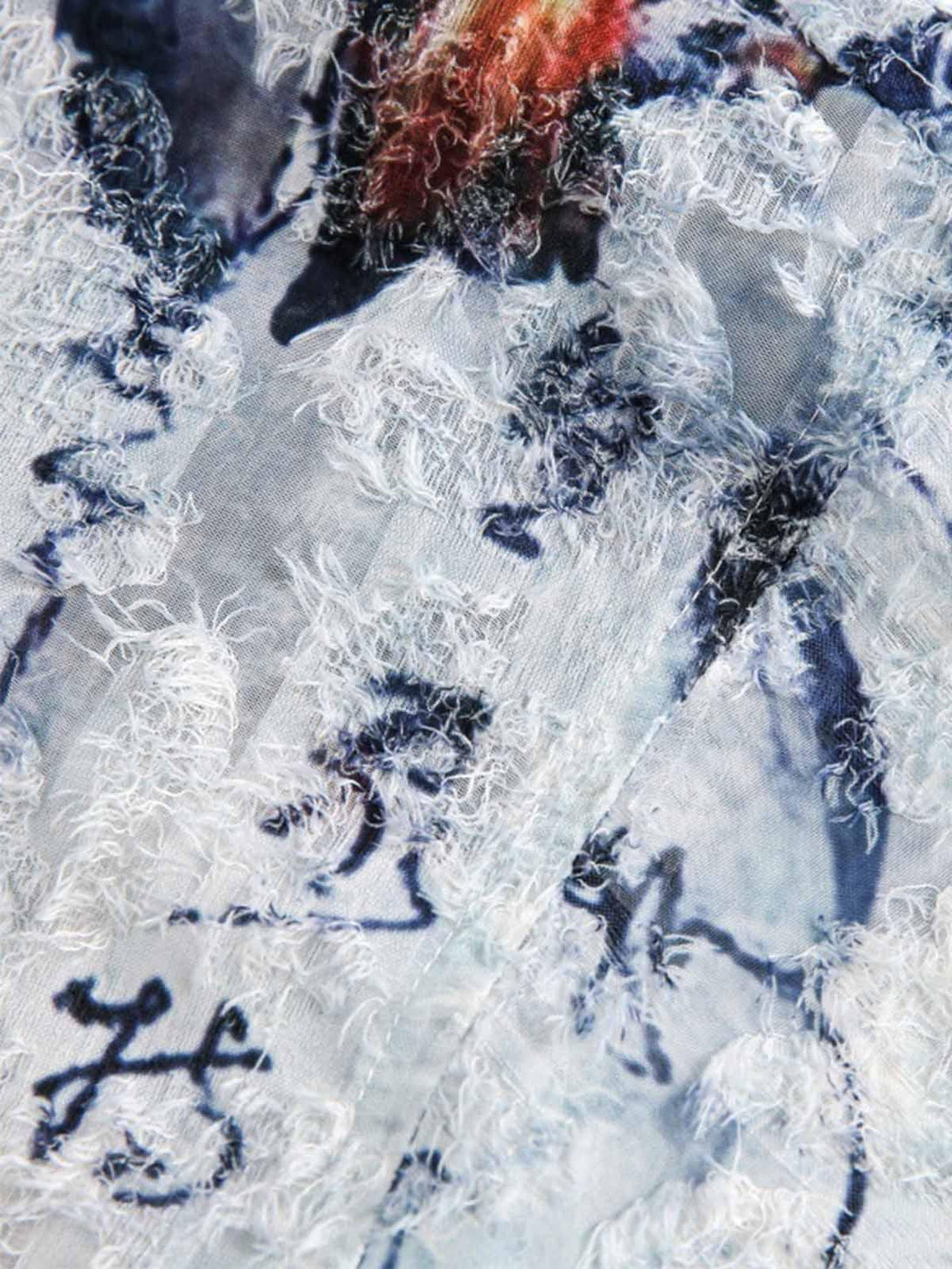 Zoomed-in texture of a TALISHKO short-sleeve shirt with traditional calligraphy print.