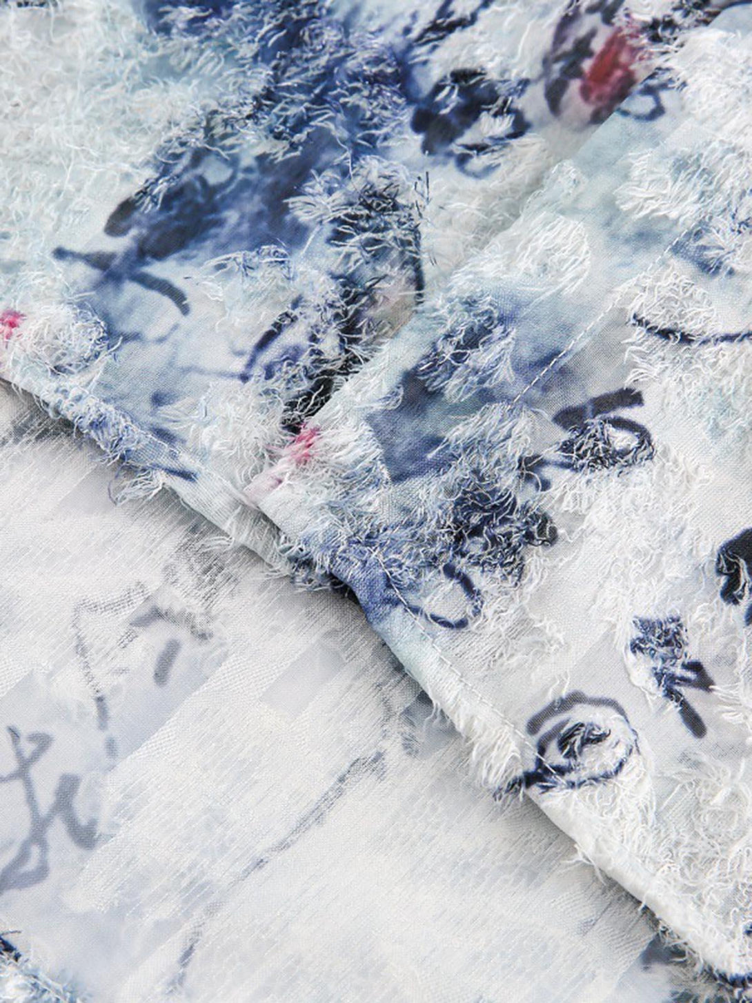 Detailed fabric and stitching of a TALISHKO short-sleeve shirt with calligraphy print.