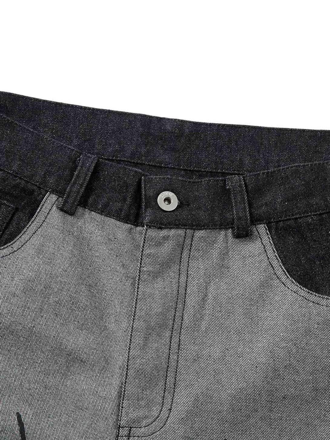 Detailed fabric and stitching of gray baggy jeans by TALISHKO, showcasing unique tribal flame design.