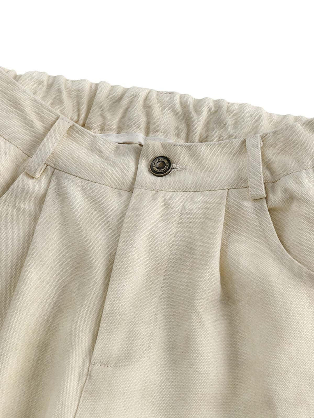 A detailed view of TALISHKO's beige wide-leg pants, showcasing elastic waist and button detail.