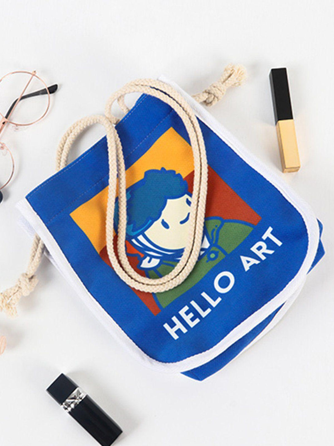 TALISHKO crossbody bag with Van Gogh cartoon print, surrounded by glasses and makeup items.