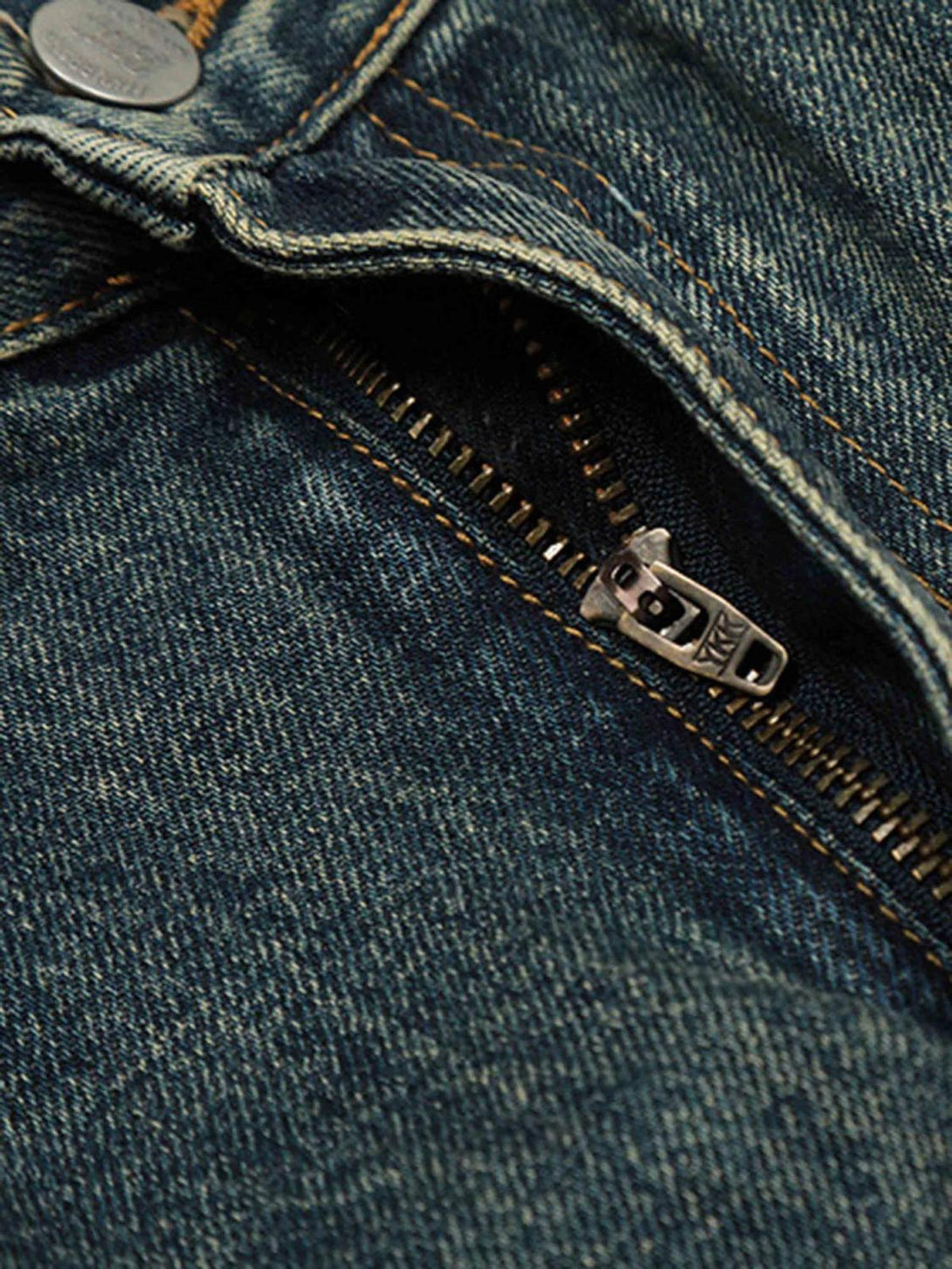 A tight crop highlighting TALISHKO's vintage baggy jeans zipper and denim texture.