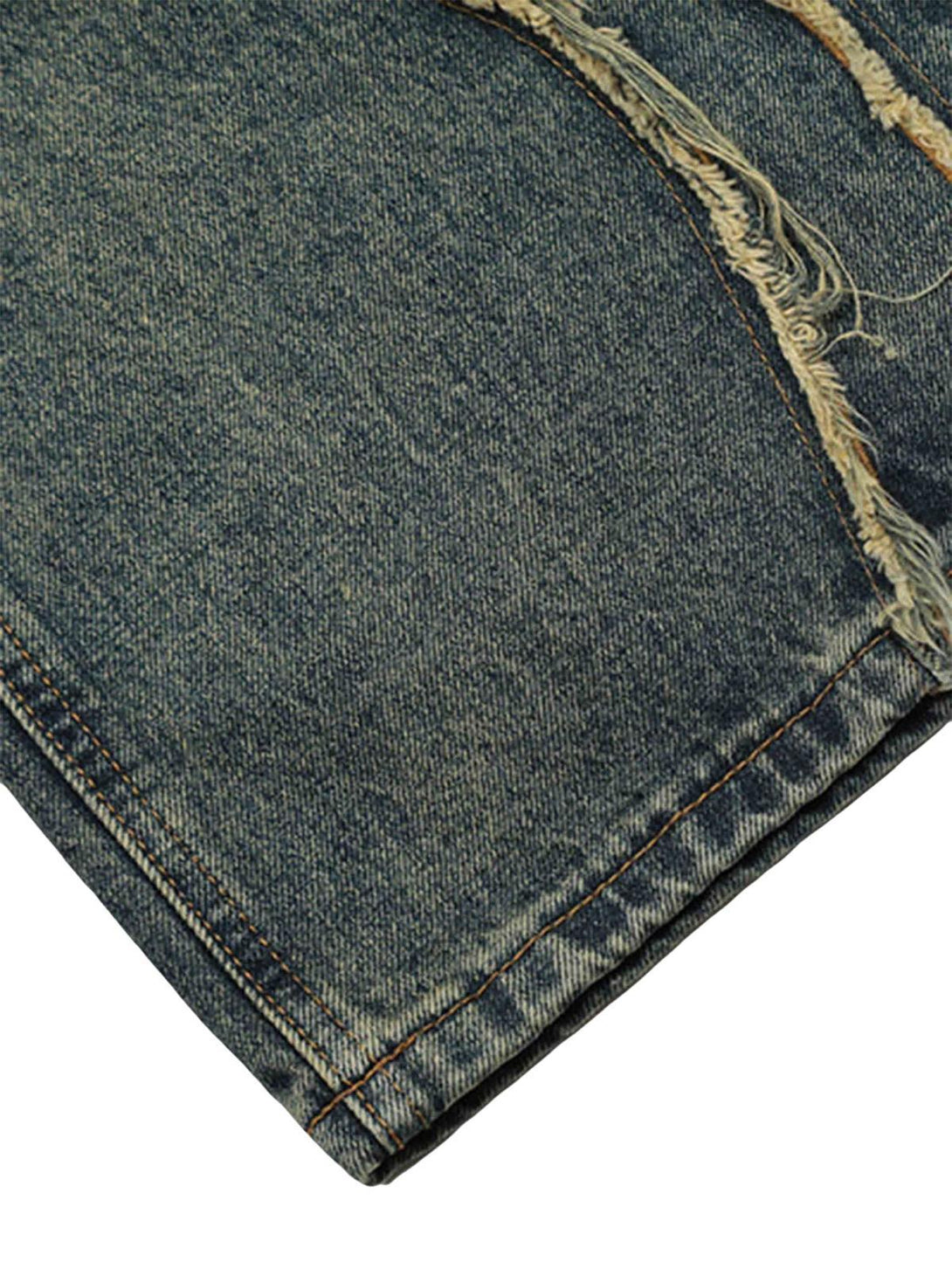 A close-up of TALISHKO's vintage baggy jeans, highlighting the distressed hem and denim texture.
