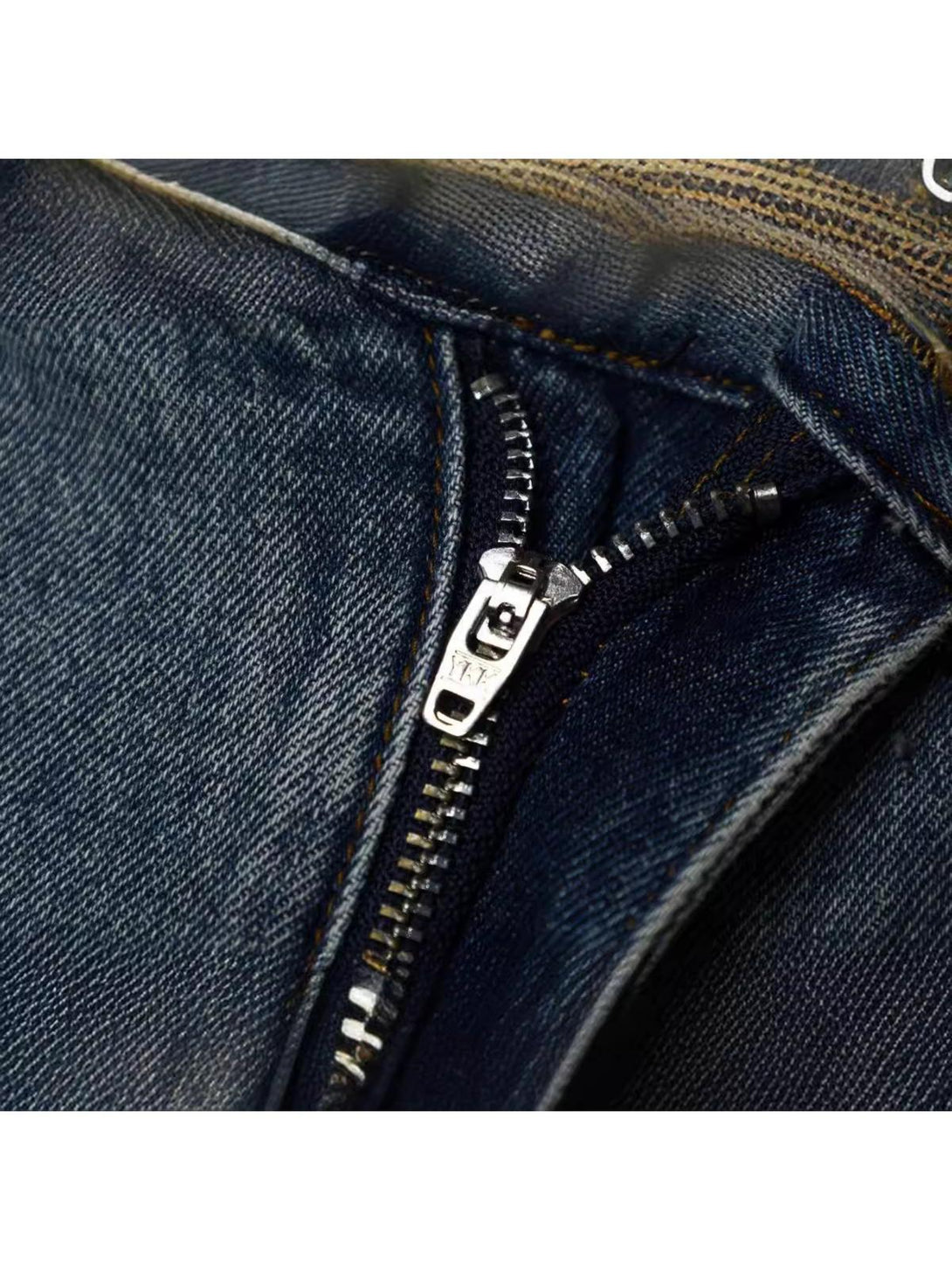Detailed view of TALISHKO's vintage patchwork cargo jeans zipper, showcasing quality craftsmanship.
