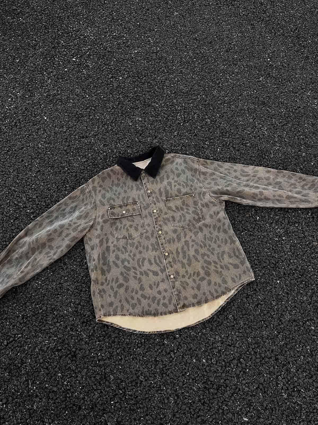 Vintage cheetah print denim shirt by TALISHKO, displayed on textured asphalt surface.