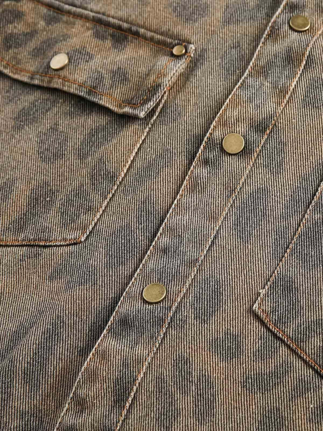 Texture and pattern showcased on TALISHKO's distressed cheetah print denim shirt with brass buttons.