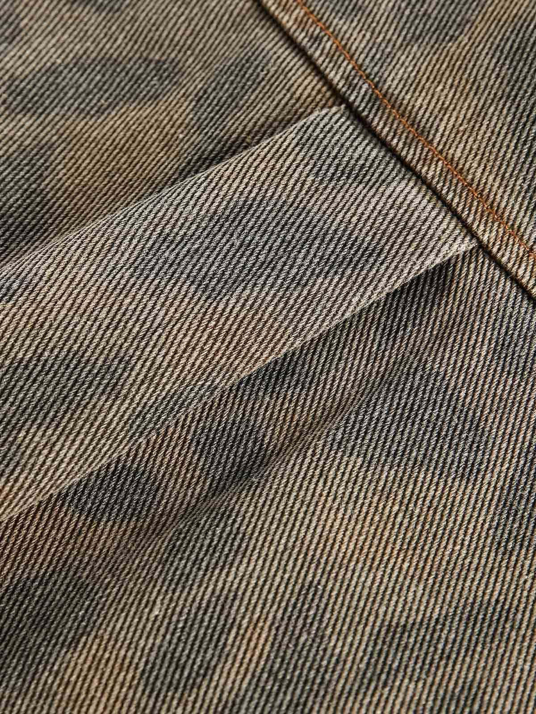A detailed look at TALISHKO's distressed cheetah print denim shirt, highlighting its texture.