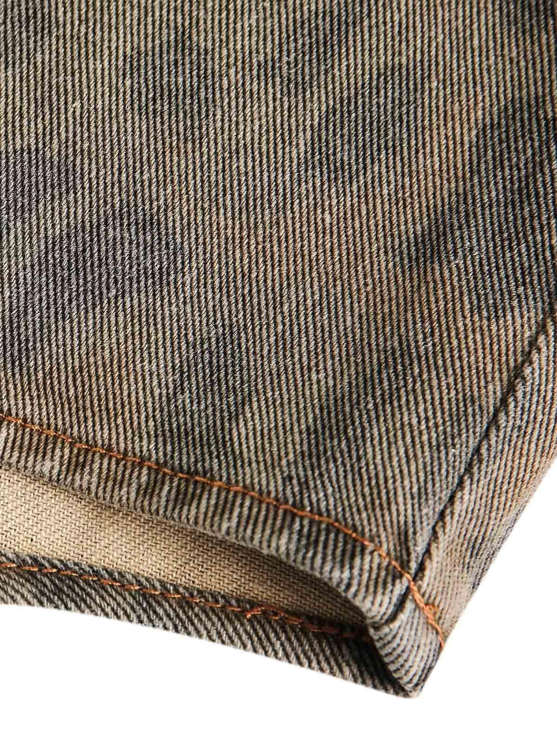 Intricate look at TALISHKO's distressed cheetah print denim shirt fabric and stitching detail.