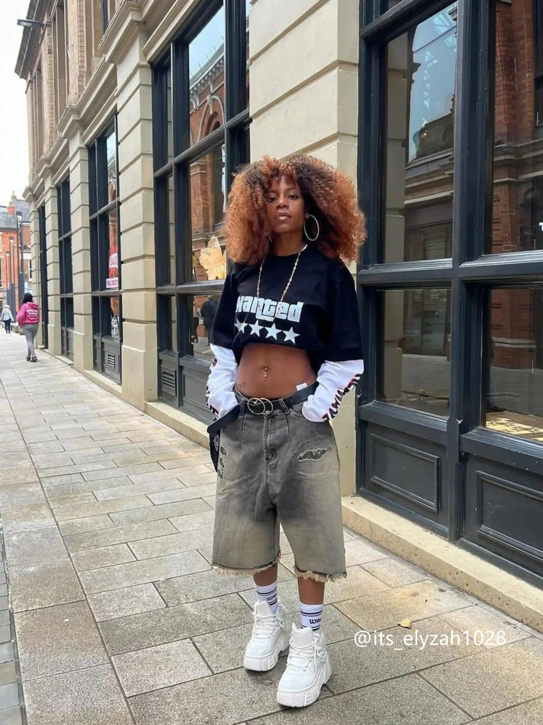 Model wearing vintage distressed denim shorts by TALISHKO, styled with chunky sneakers.