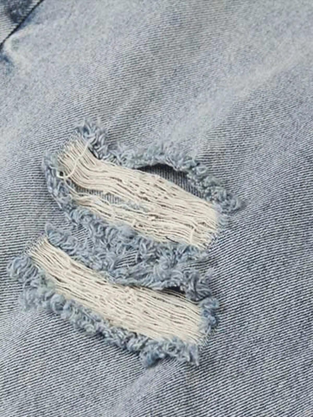 A tight crop highlighting TALISHKO vintage distressed jeans' texture and frayed detailing.
