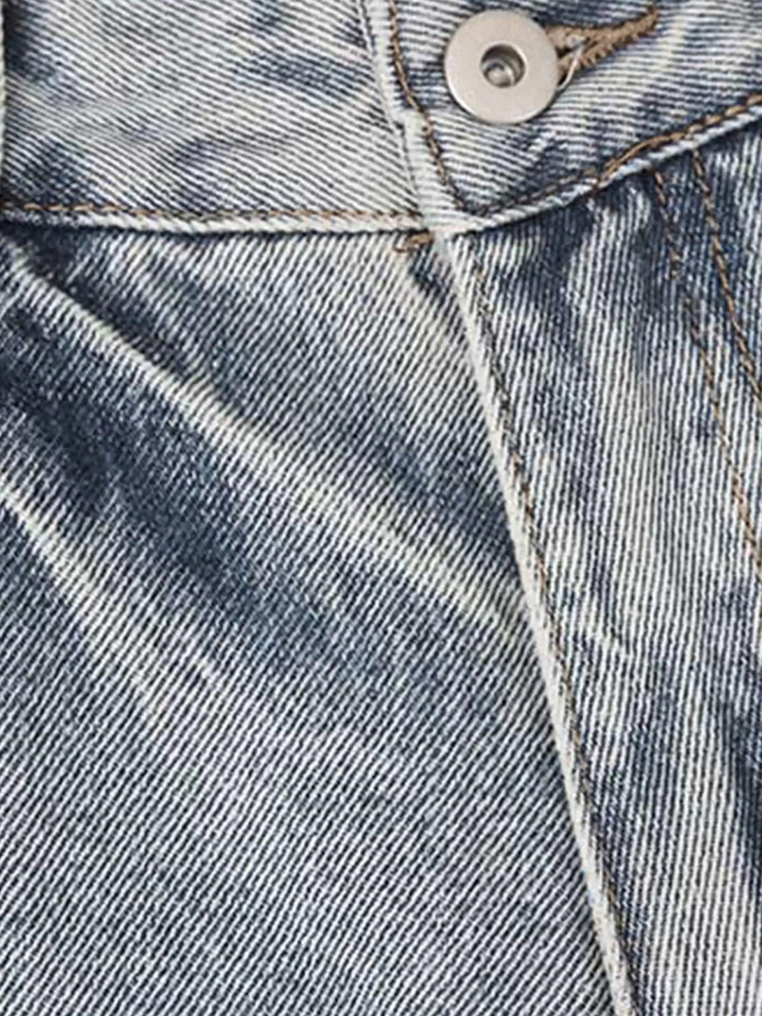Intricate look at TALISHKO vintage distressed jeans, showcasing texture and unique stitching.