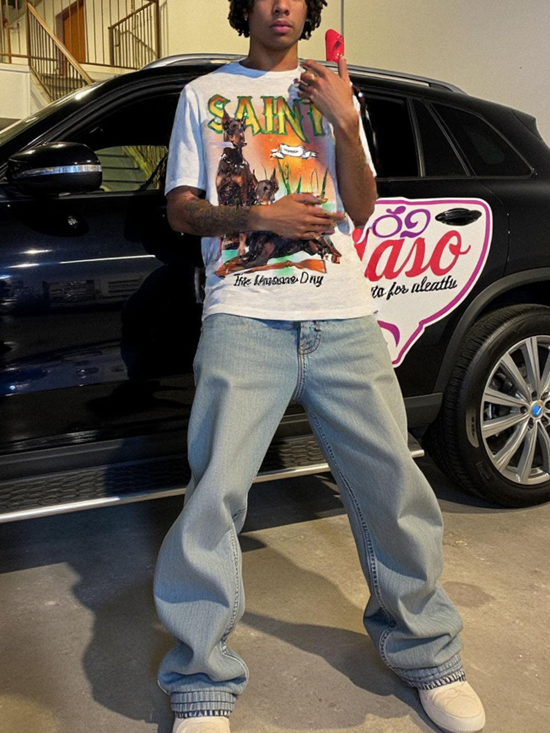 Model wearing a TALISHKO vintage Doberman print T-shirt with relaxed jeans in an urban setting.