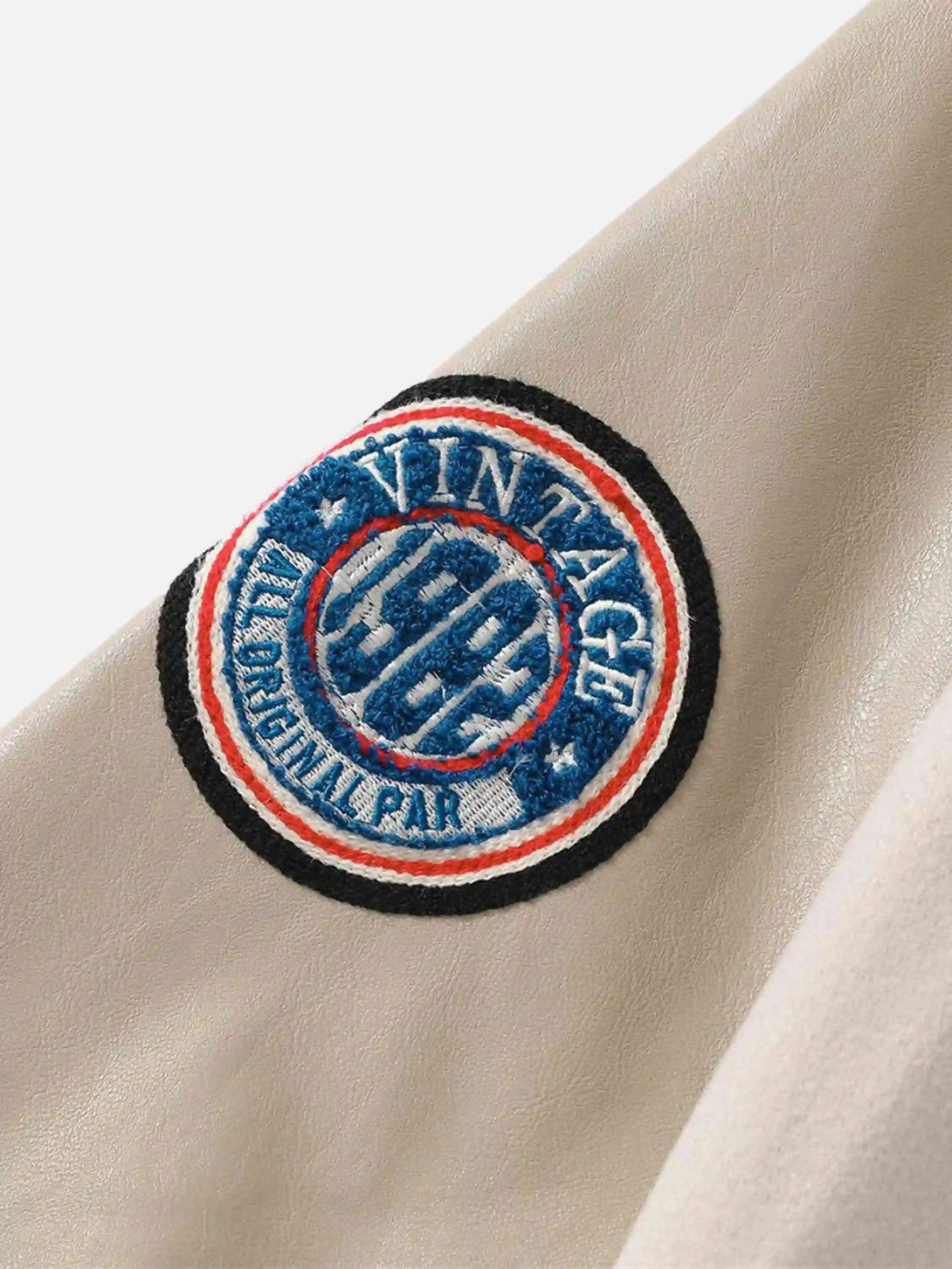 A close-up of the vintage embroidered patch on a TALISHKO baseball jacket, showcasing intricate design.