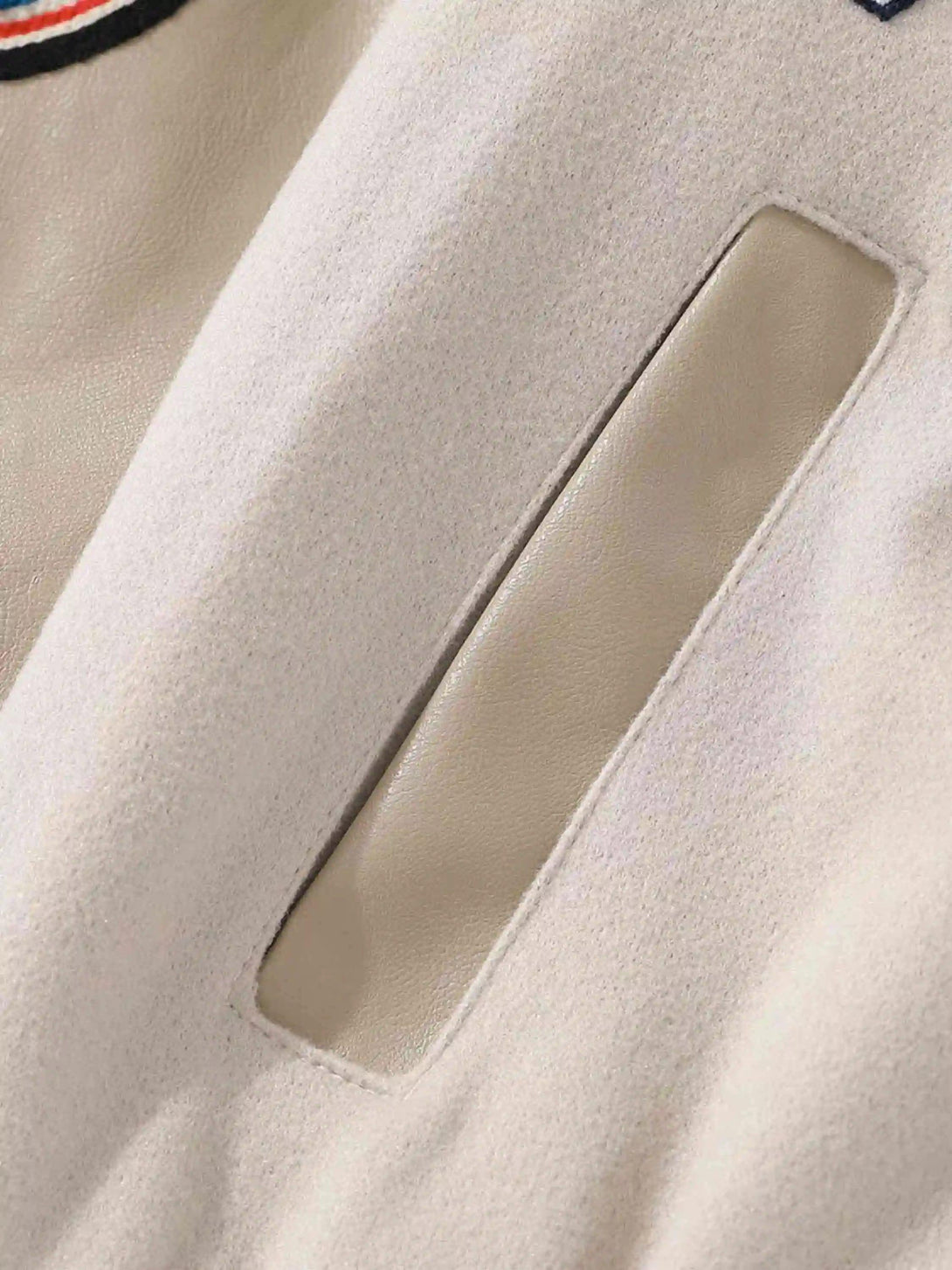 Detailed fabric and stitching on a TALISHKO vintage embroidered baseball jacket, emphasizing texture.