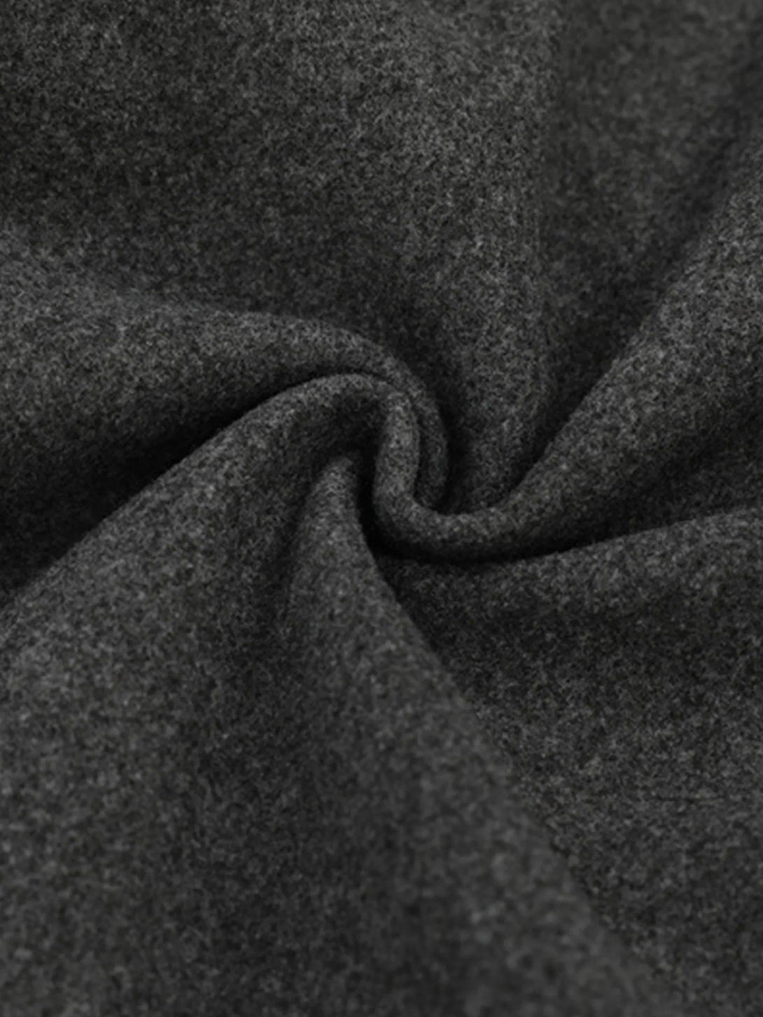 Tight crop highlighting the texture of a gray varsity baseball jacket by TALISHKO.