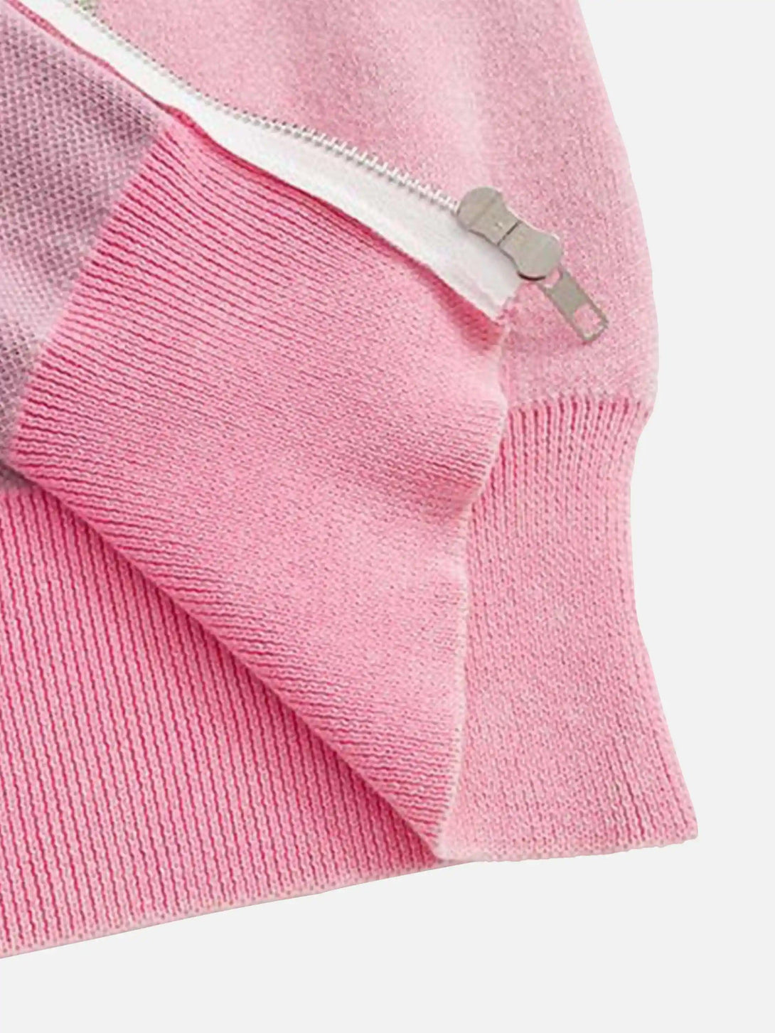 A close-up of a pink TALISHKO cardigan, highlighting the zipper and ribbed knit texture.