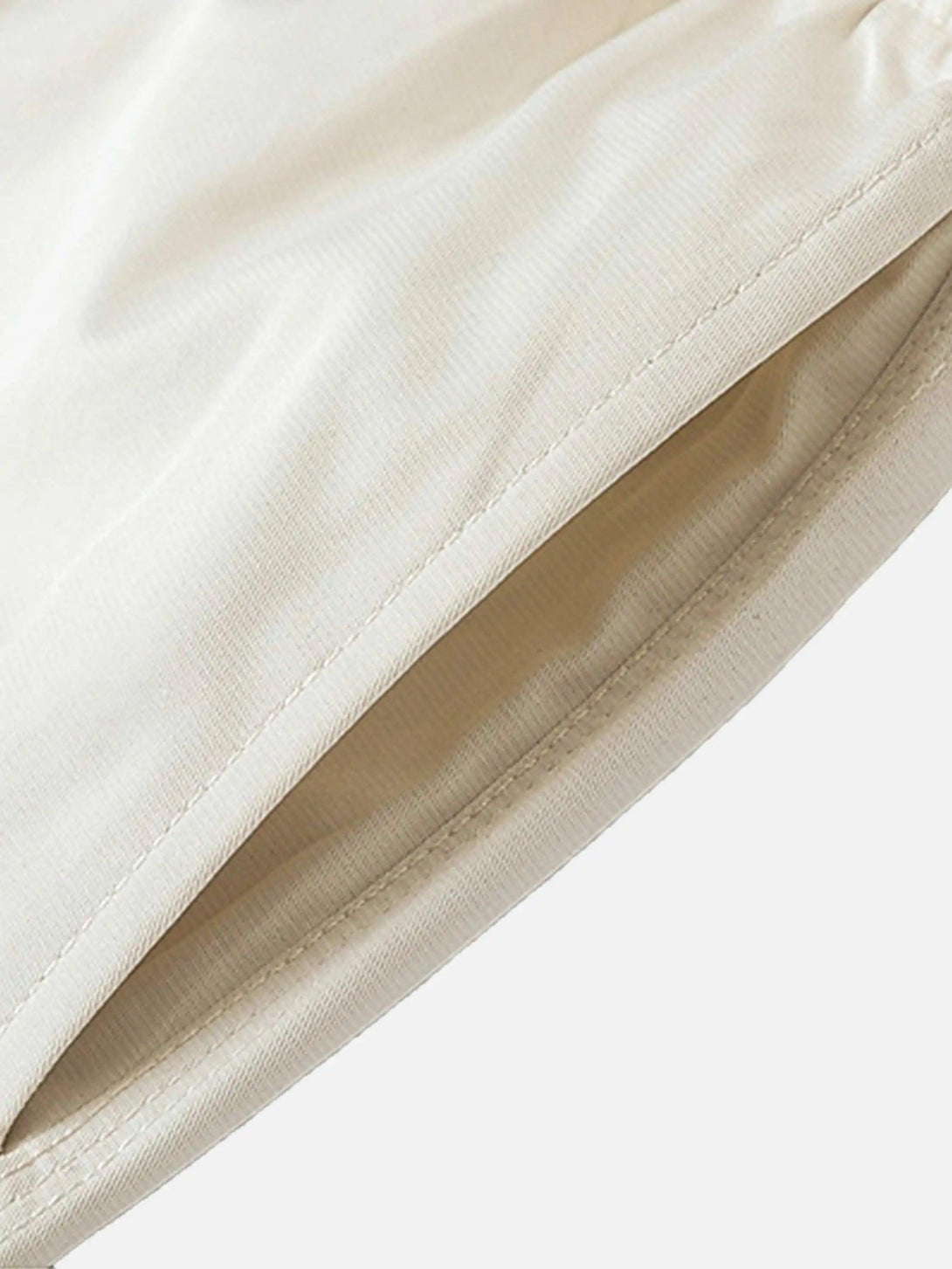 "Detailed stitching and fabric close-up of TALISHKO vintage flame shorts in a neutral tone."