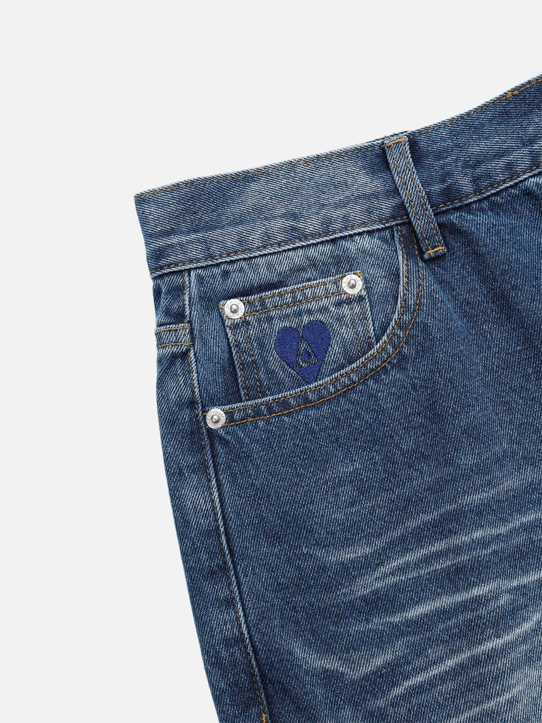 A detailed view of TALISHKO vintage folds loose jeans, highlighting the unique pocket embroidery.