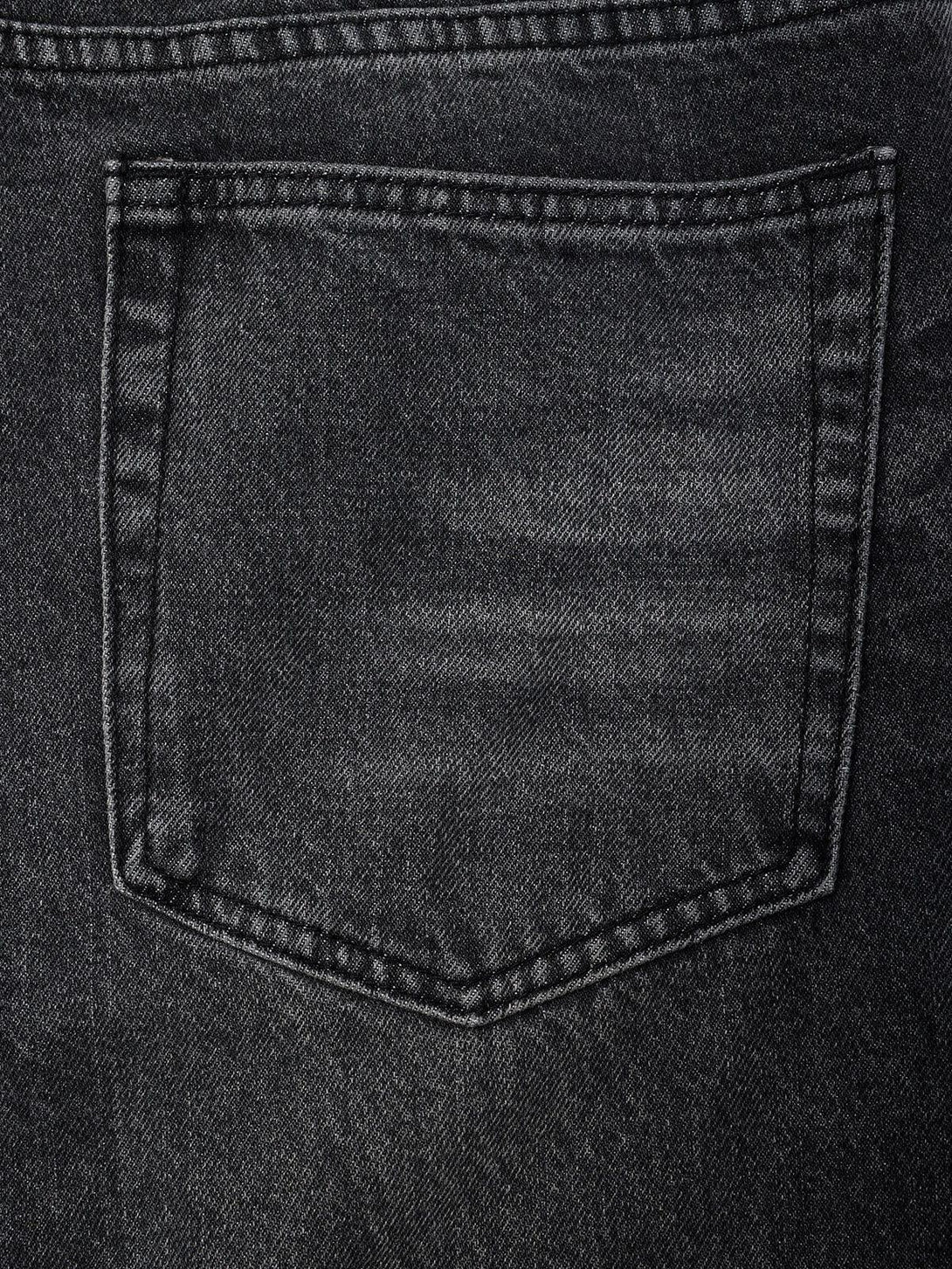 Detailed fabric and stitching on TALISHKO vintage folds loose jeans, highlighting the texture.