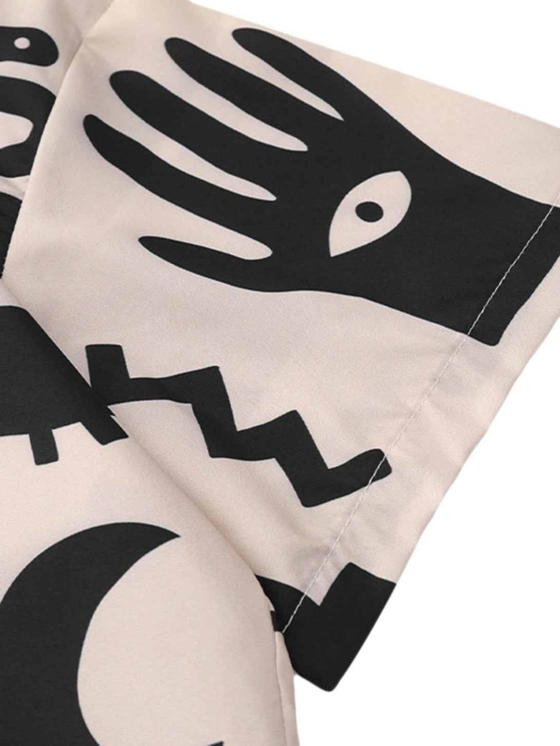 Zoomed-in texture of abstract black prints on a vintage short sleeve shirt by TALISHKO.