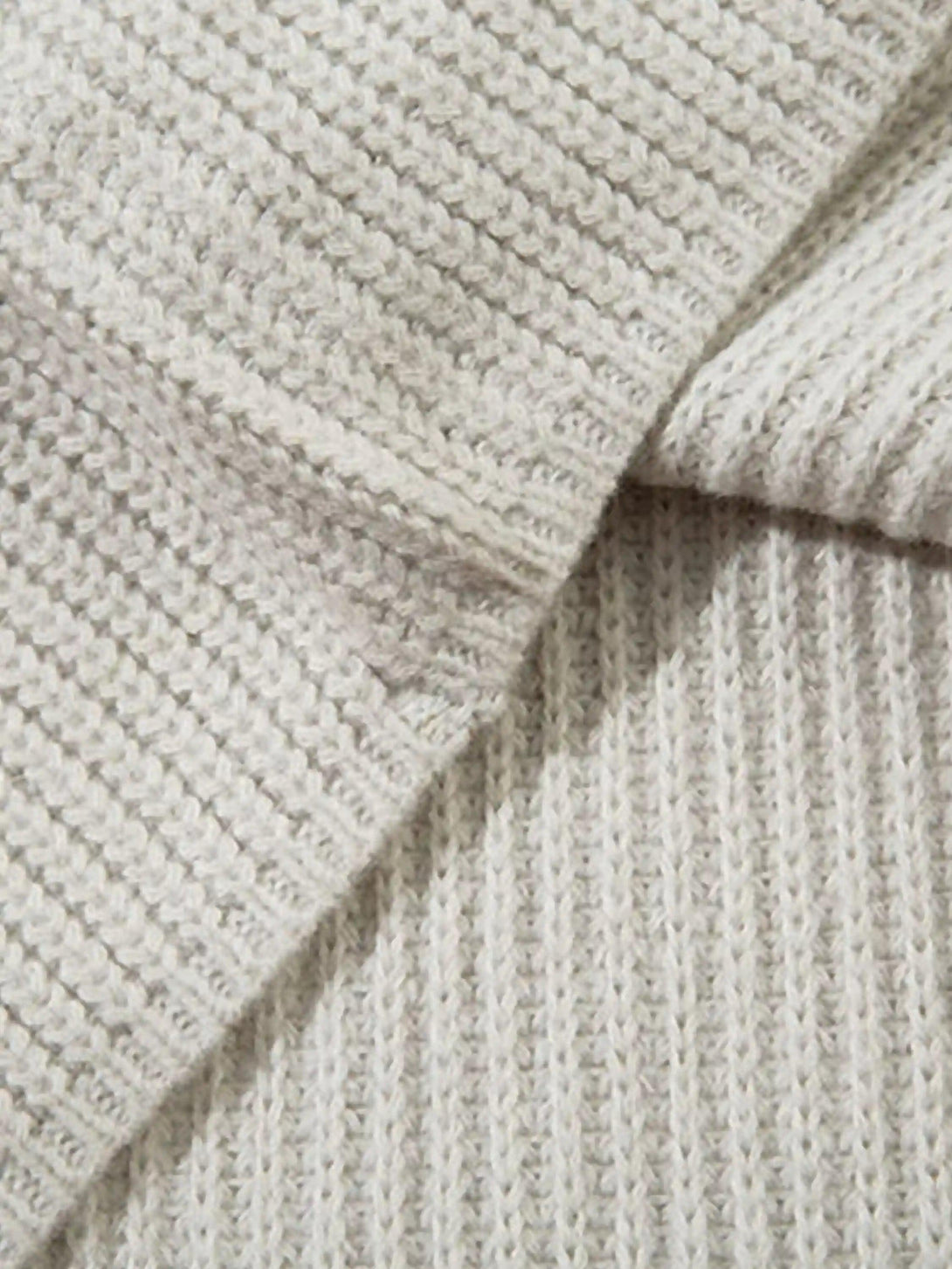 A tight crop highlighting TALISHKO's vintage graffiti zip-up cardigan, emphasizing texture.