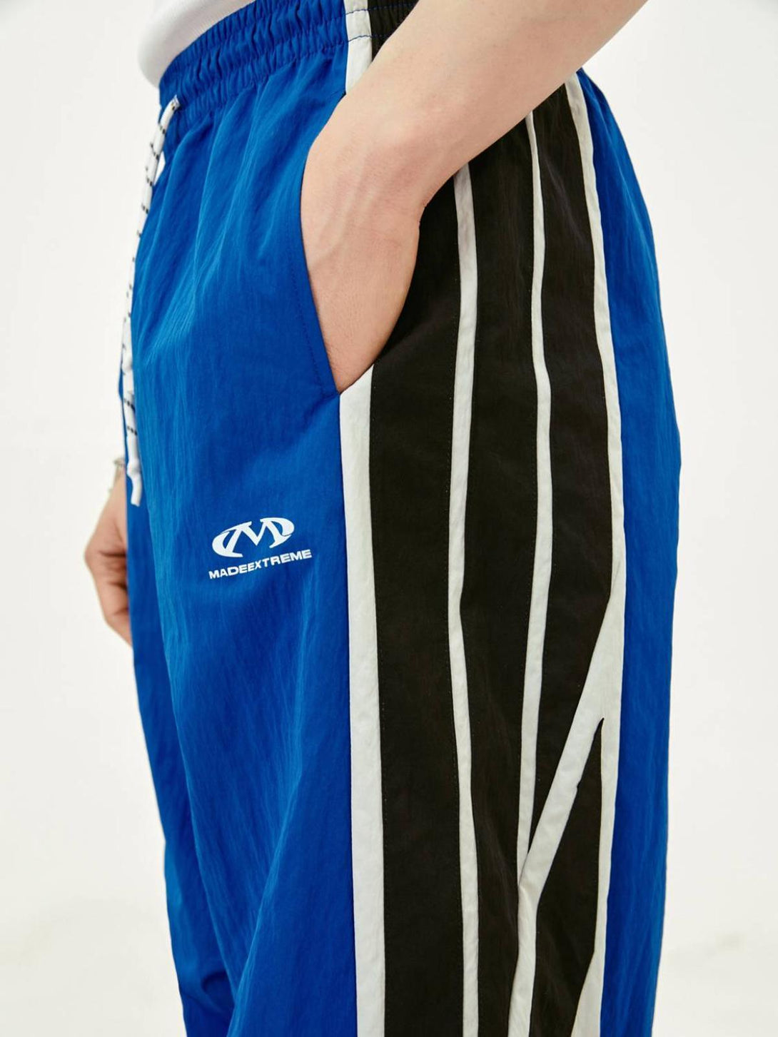 TALISHKO vintage sweatpants in blue with black and white stripes, side view detail.