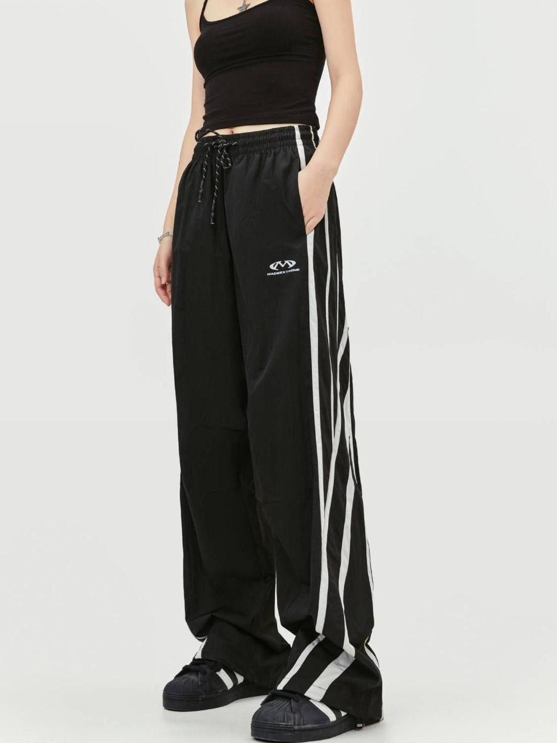 Model wearing black TALISHKO vintage line sweatpants featuring striking side stripes.