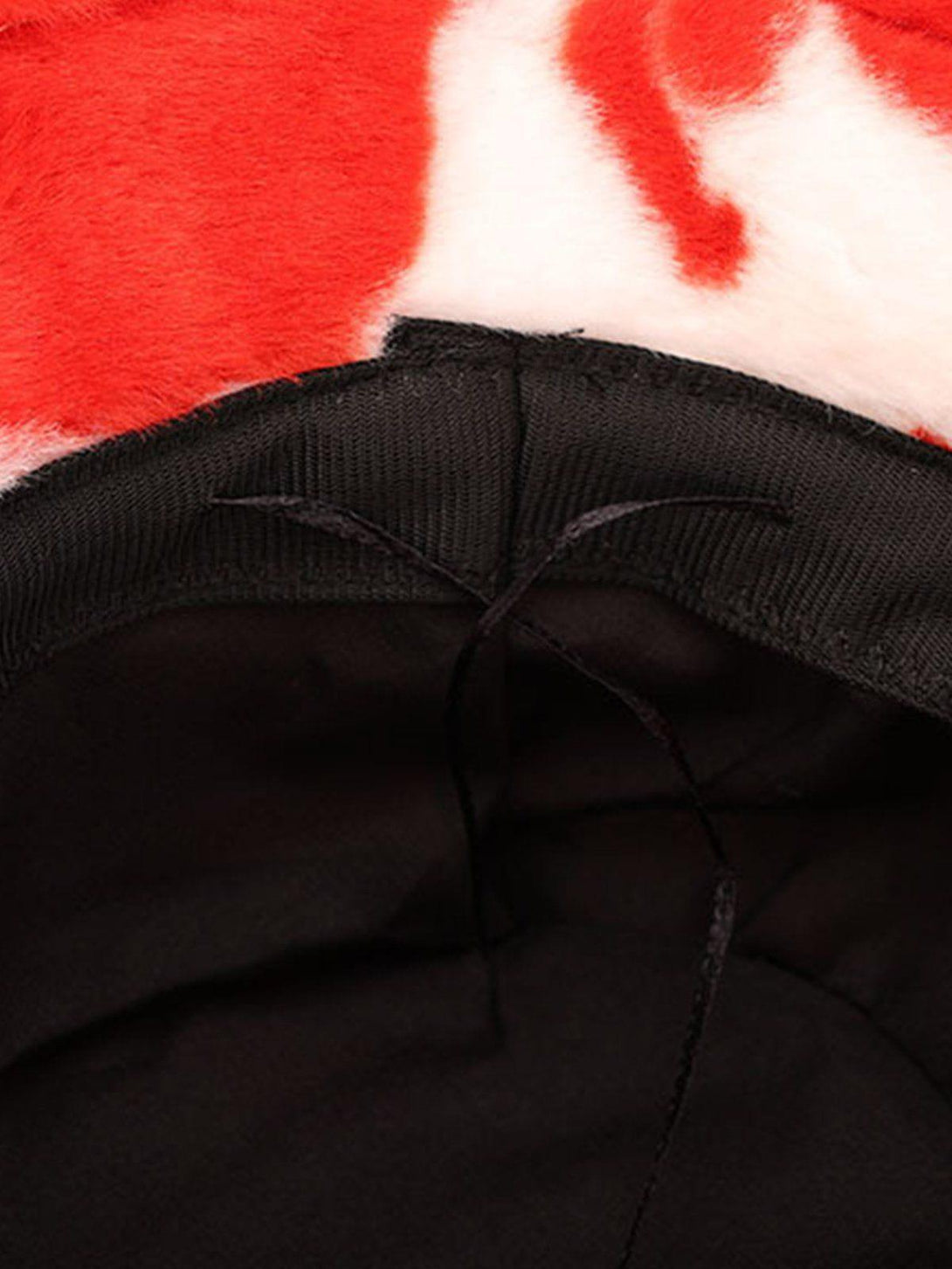 Detailed look at TALISHKO's vintage milk cow pattern hat, highlighting the vibrant red and white fabric.