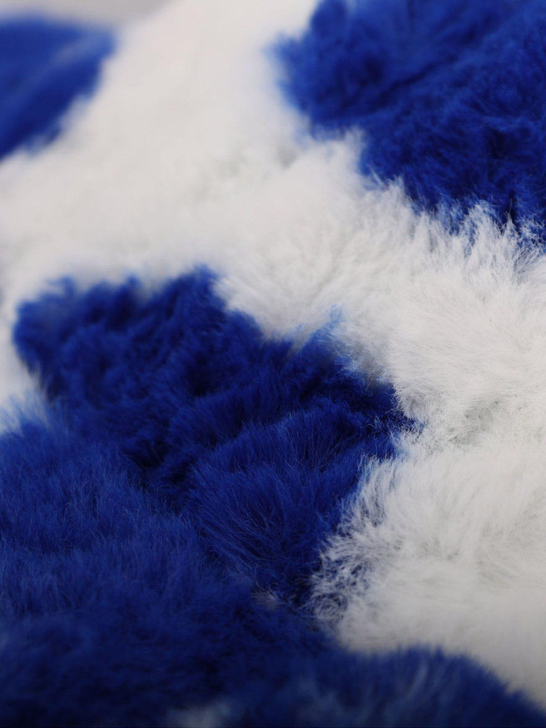 A close-up of TALISHKO's vintage milk cow pattern hat in blue and white, highlighting its plush texture.