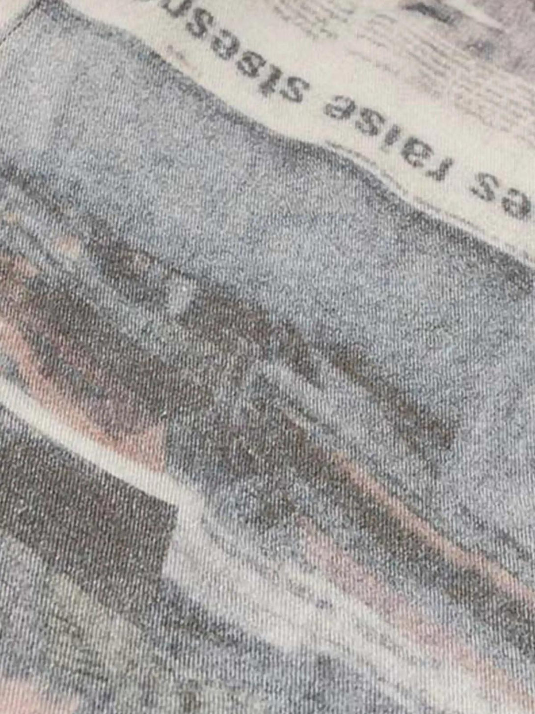 Zoomed-in texture of TALISHKO's vintage newspaper print pants, highlighting intricate details.