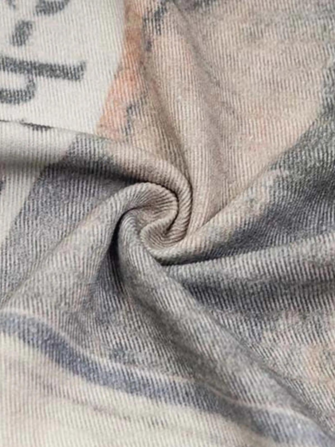 A tight crop highlighting TALISHKO's vintage newspaper print fabric, showcasing unique texture.