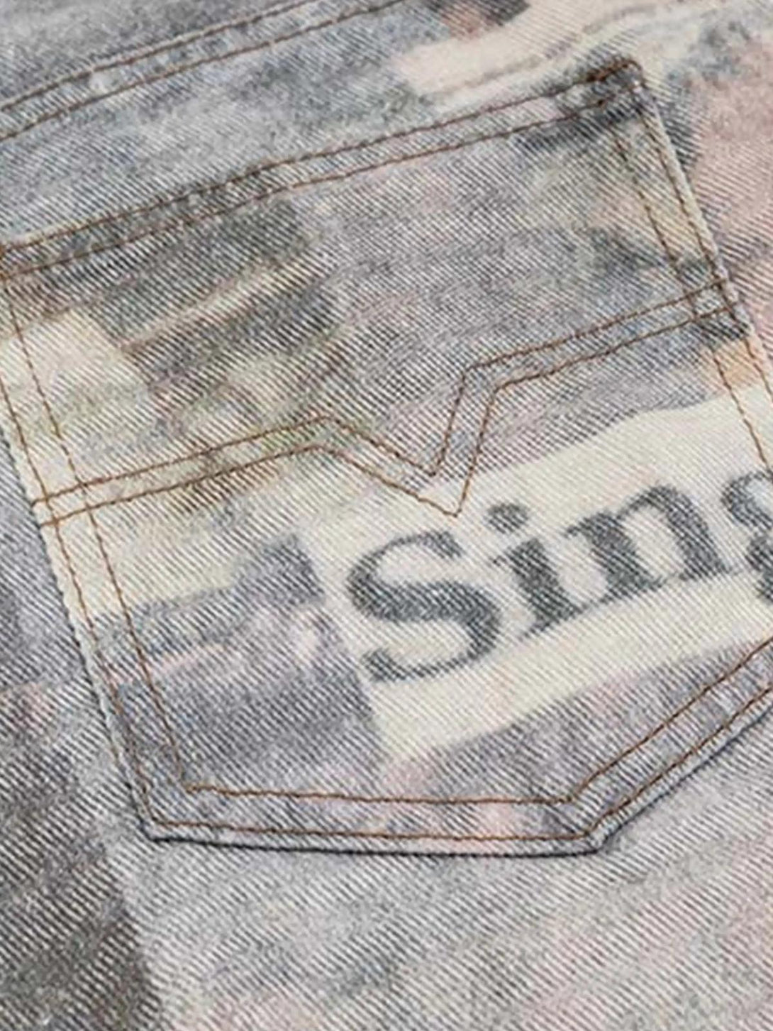 Focusing on the back pocket of TALISHKO's vintage newspaper print pants, highlighting unique design.