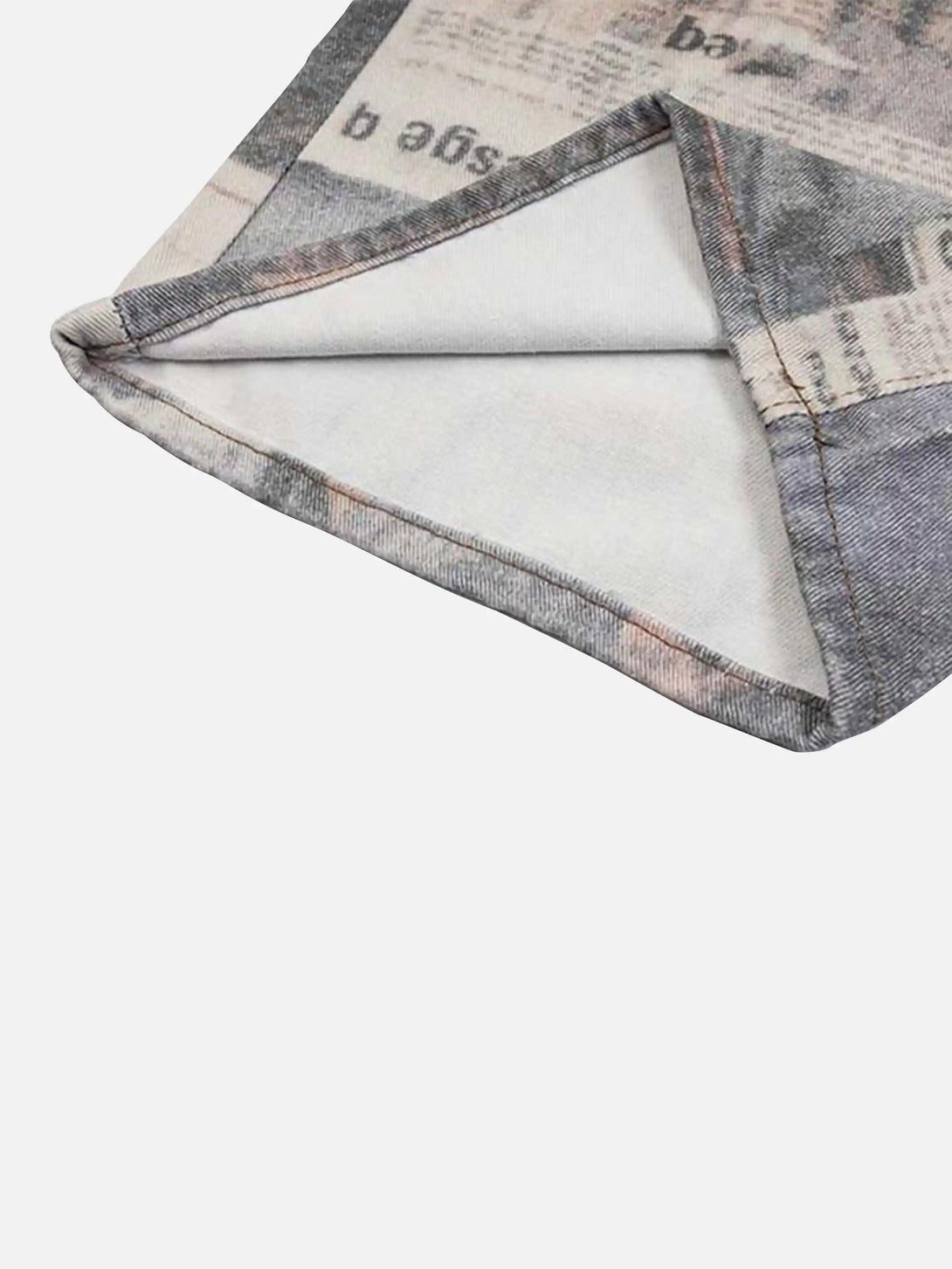 Detailed fabric and stitching of TALISHKO's vintage newspaper print pants, highlighting unique design.