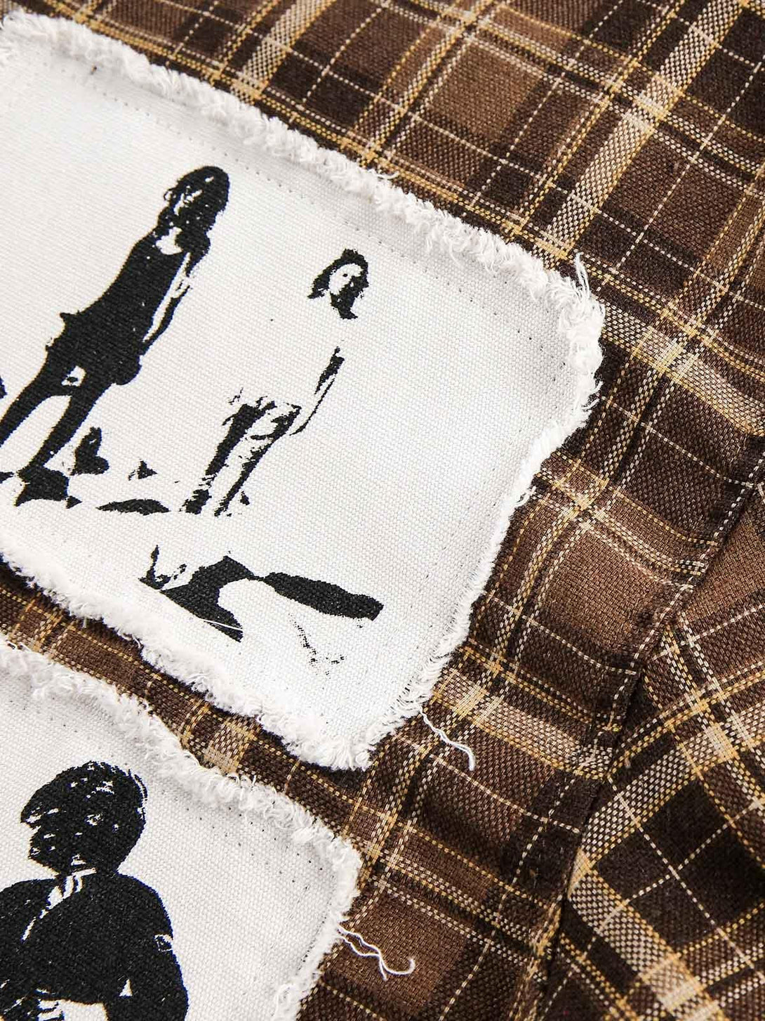 Intricate look at TALISHKO's vintage portrait applique on brown plaid fabric, showcasing unique style.