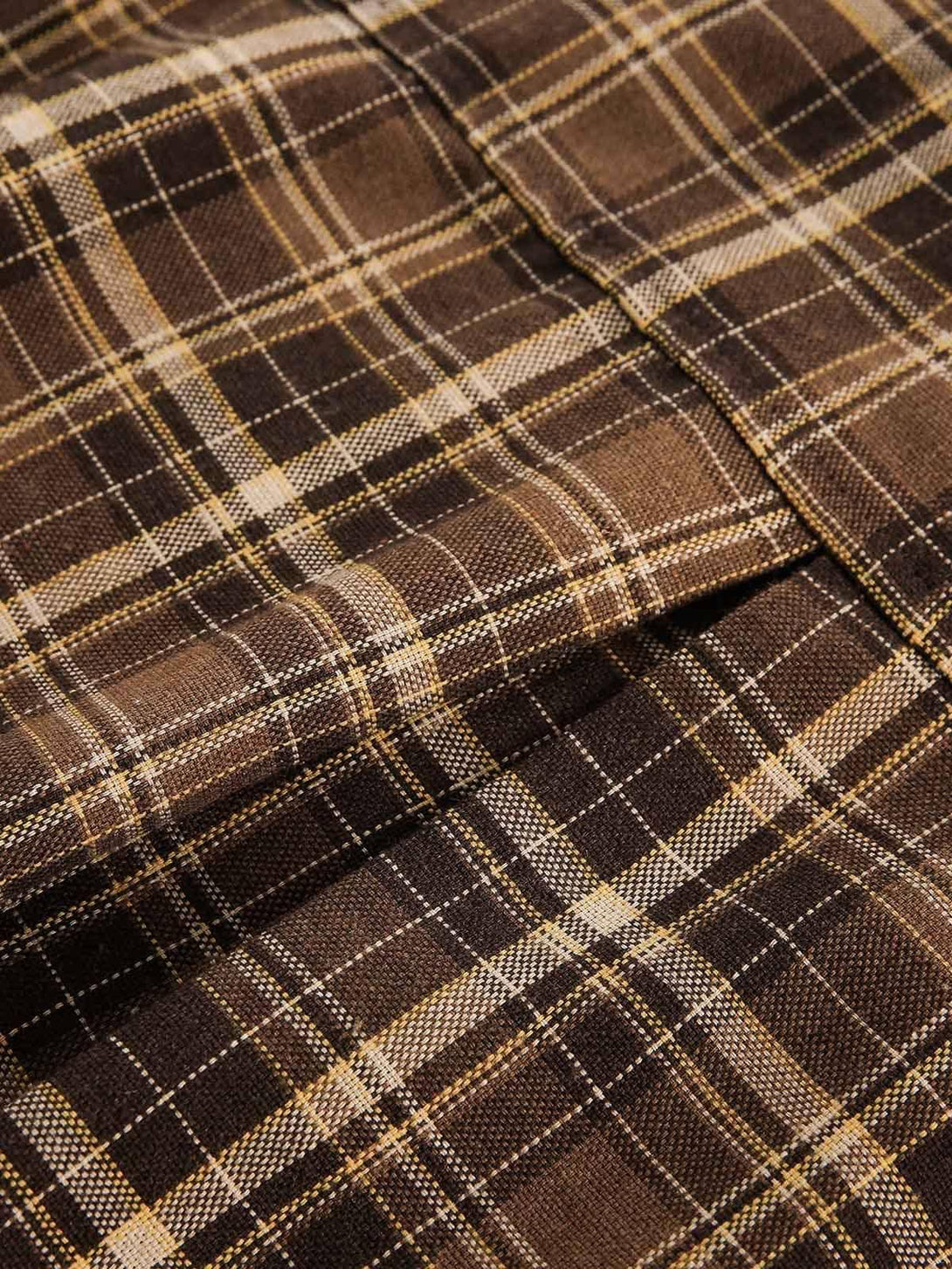 Detailed fabric and stitching of a TALISHKO shirt, showcasing the classic brown plaid pattern.