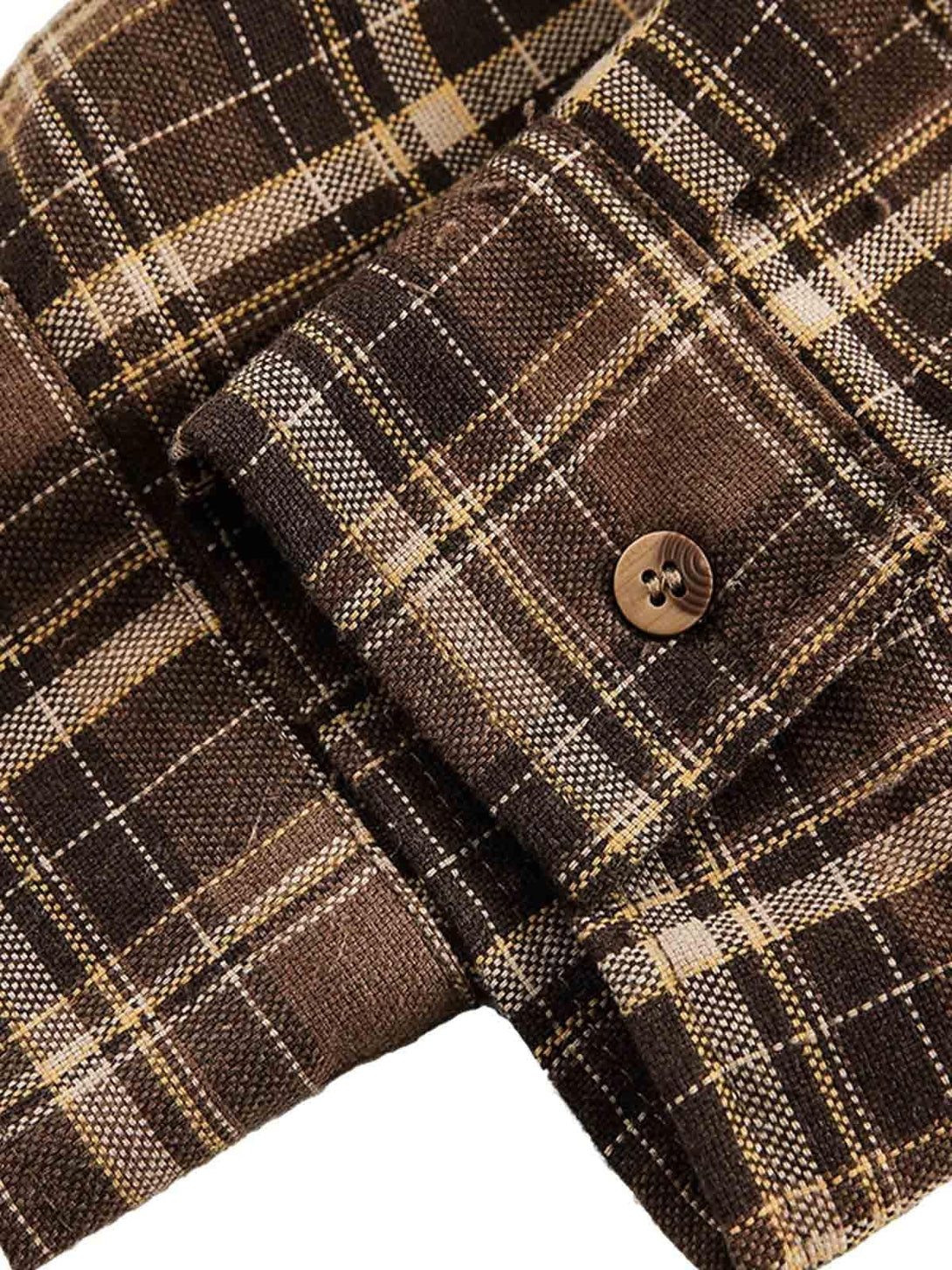Focusing on the texture of TALISHKO's brown plaid shirt, highlighting the button cuff detail.