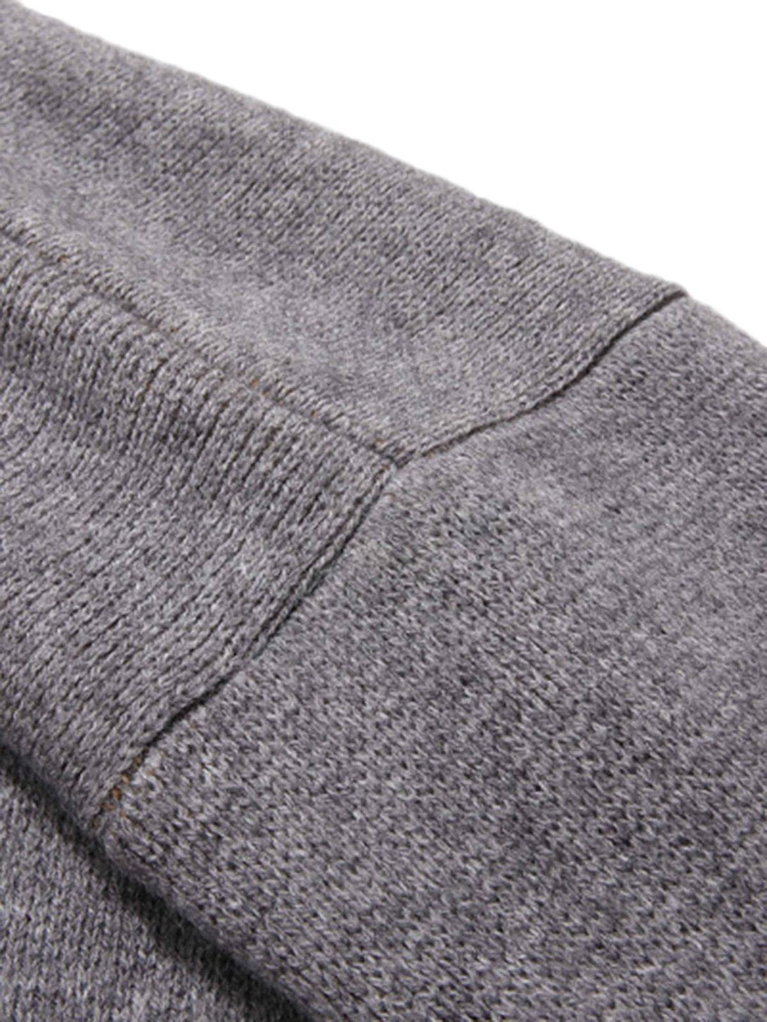 Detailed fabric and stitching of a gray knit sweater cuff by TALISHKO, highlighting vintage charm.