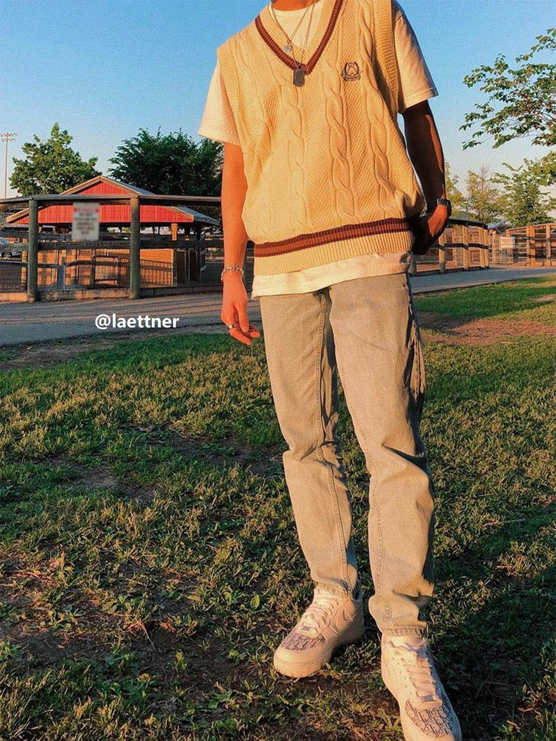 A model wearing a vintage preppy knit sweater vest by TALISHKO, paired with casual jeans.