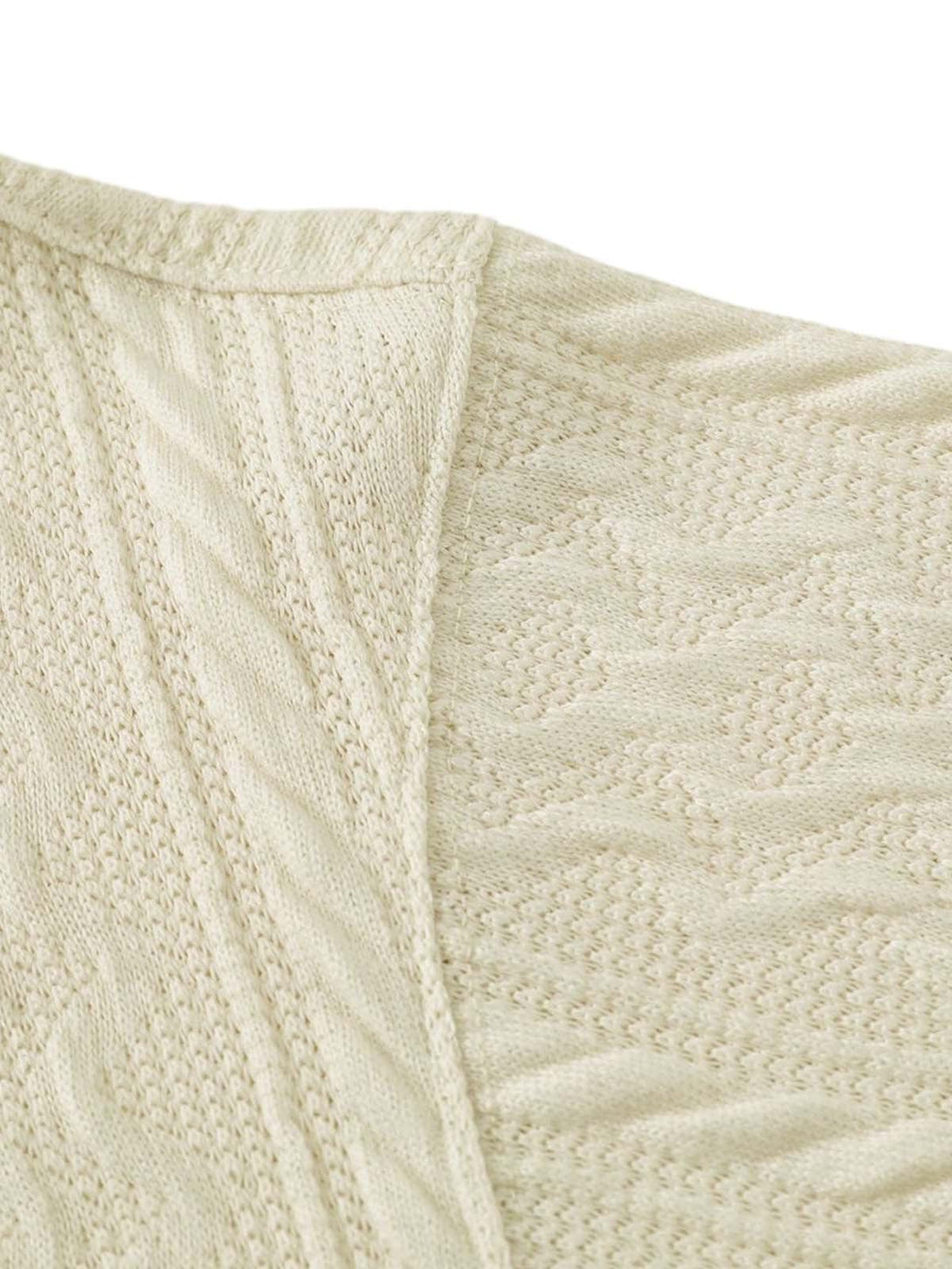 Zoomed-in texture of the cream knit sweater by TALISHKO, showcasing intricate cable patterns.