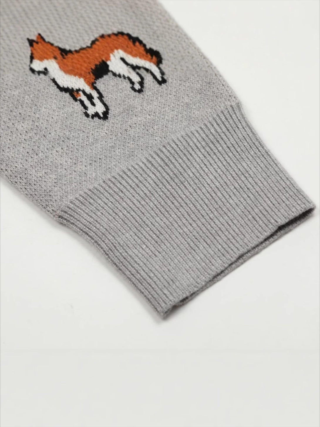 A detailed view of TALISHKO's vintage cardigan sleeve with playful puppy embroidery.