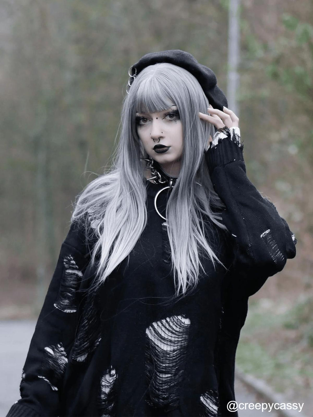 Model in a vintage ripped oversized sweater by TALISHKO, styled with a beret and bold makeup.