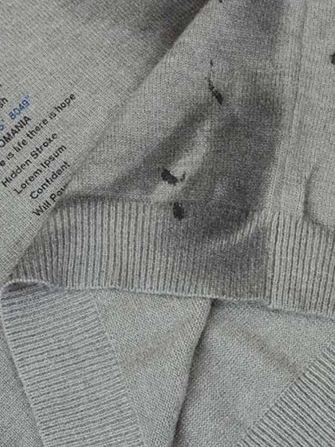 A close-up of the distressed fabric on TALISHKO's vintage ripped tie-dye sweater.